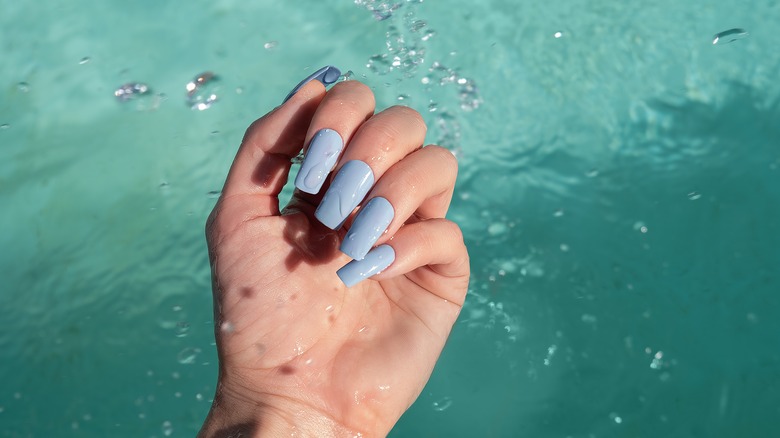 baby blue manicure surrounded by water