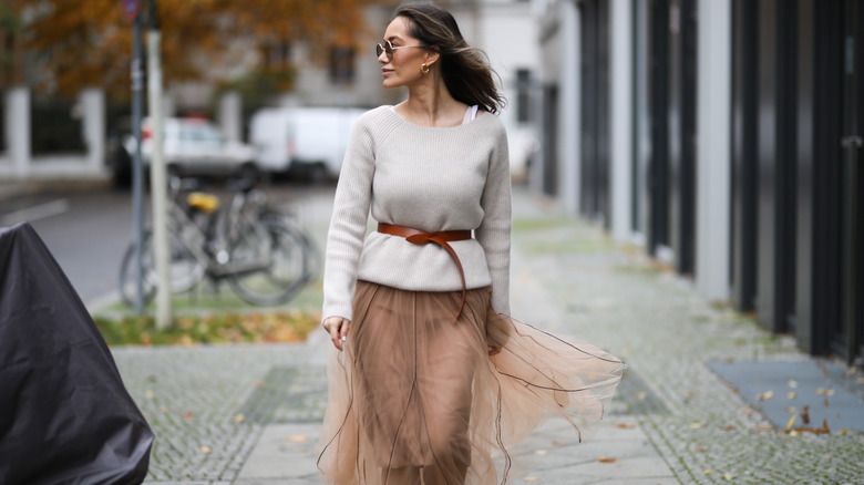 woman walking in boat neck sweater