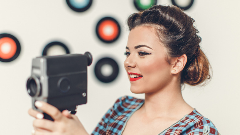 Retro woman holding an 8mm camera