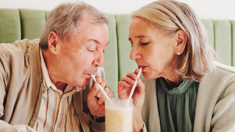 Mature couple sharing a milkshake