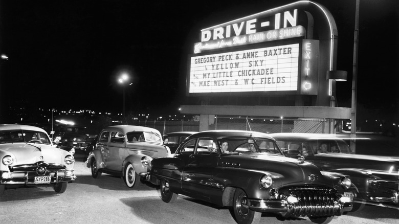 Black-and-white photo of cars at a drive-in theater