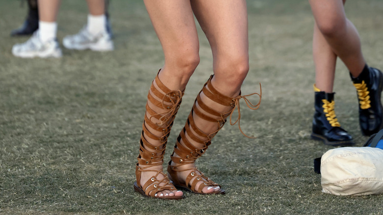 Close-up to a woman wearing brown lace-up gladiator sandals