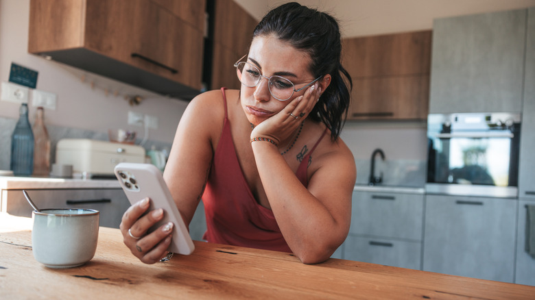 Woman texting in kitchen