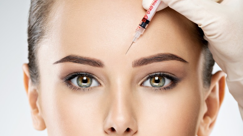 Close up of model receiving Botox injection to forehead