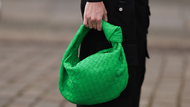 Woman wearing green Bottega Veneta purse