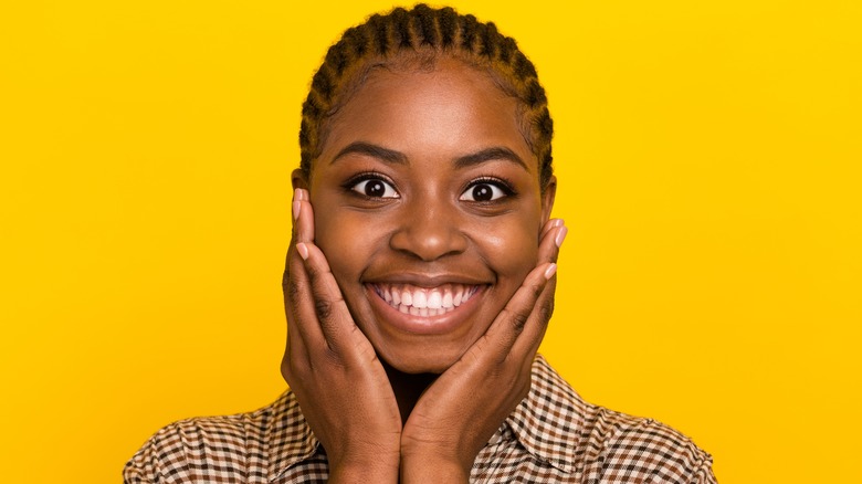 smiling person with cornrows