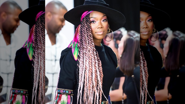 Brandy with multicolored braids and a large black hat