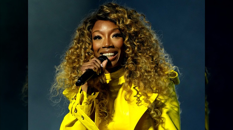 Brandy wearing a bright yellow top and honey blond curls