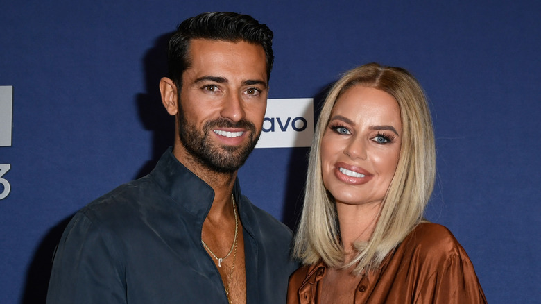Sergio Carrallo and Caroline Stanbury pose together in front of a navy blue background