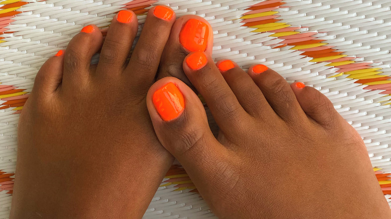 Woman with a bright orange pedicure