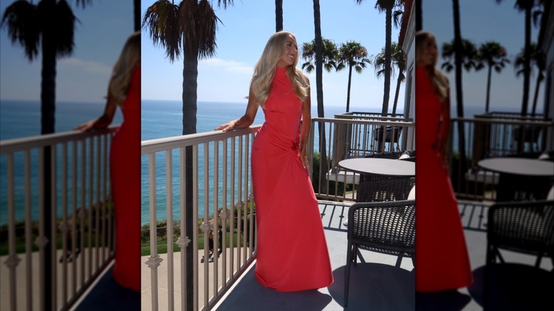 Brittany Mahomes poses on a balcony in a coral maxi dress.