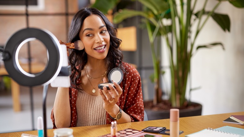 woman applying powder foundation