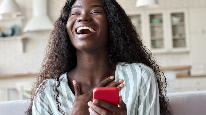 Smiling woman holding cell phone