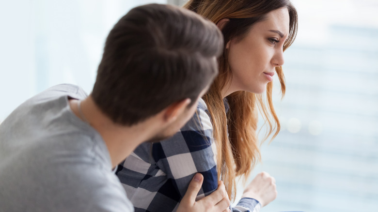 man comforting upset woman