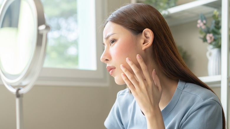 woman looking at face skin