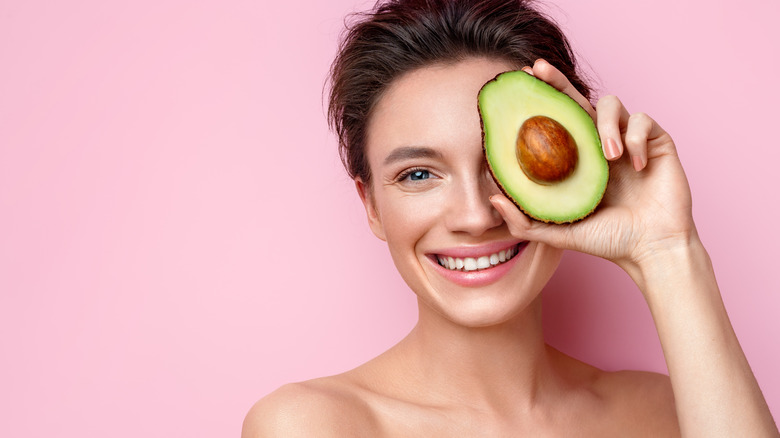 Woman with half avocado