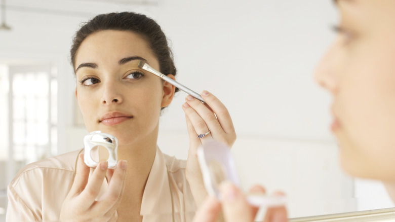 woman applying eye makeup