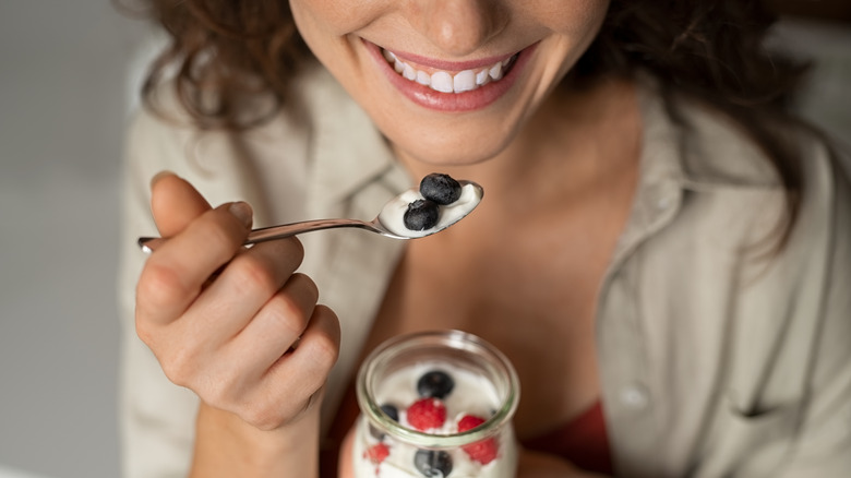 Young women eats homemade yogurt.
