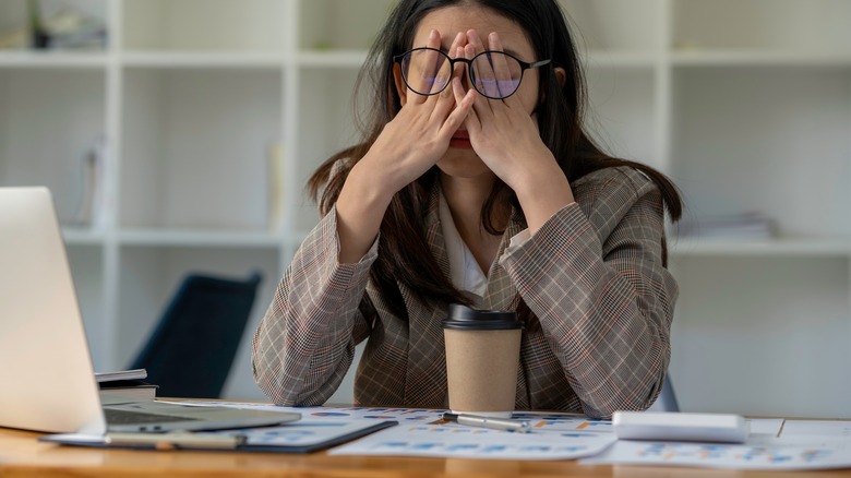 Tired woman rubbing her eyes 