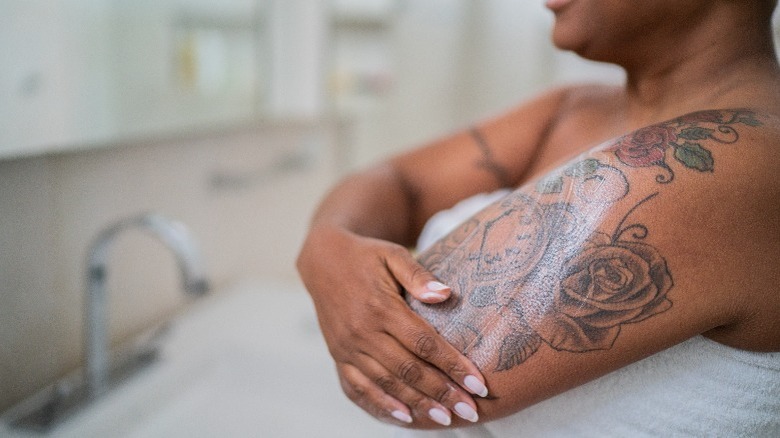 Woman washing a tattoo on arm