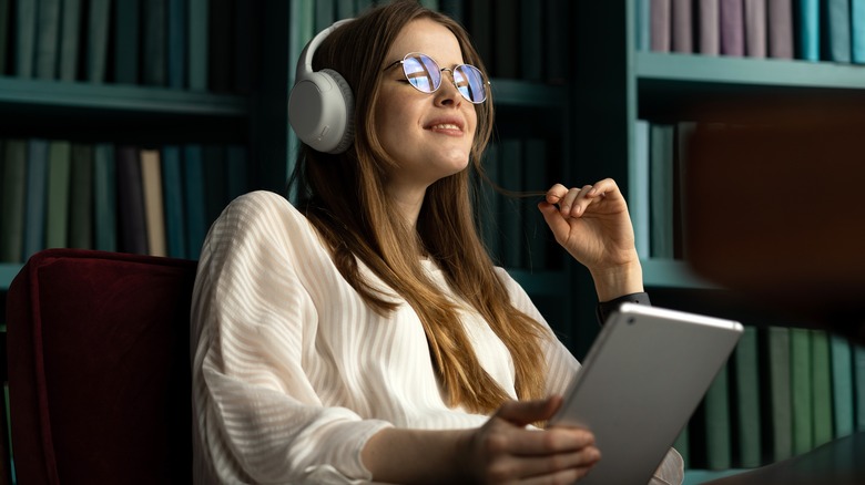 Woman with tablet wearing headphones 