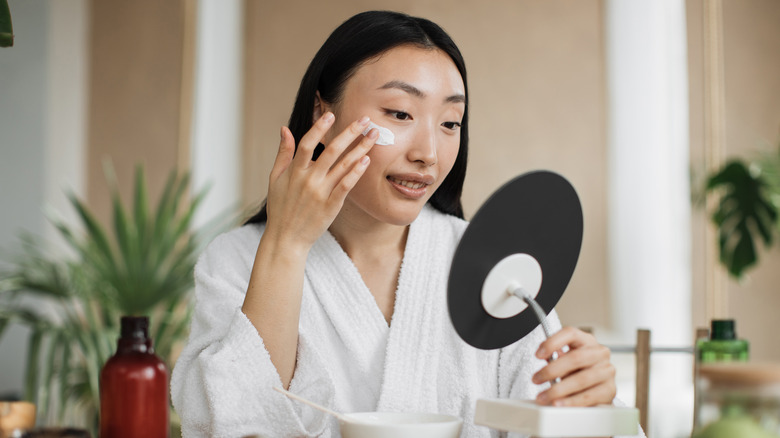 woman applying skincare product