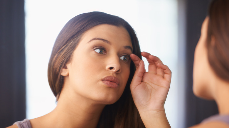 woman looking at her eyelashes