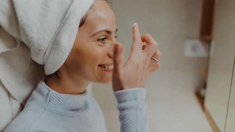 Woman applying acne treatment