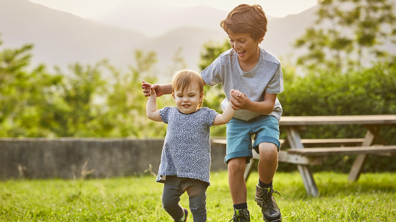 Older brother helping baby walk