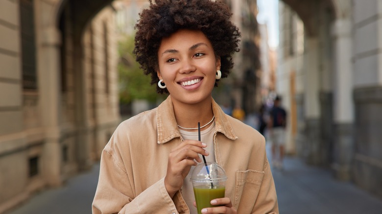 woman drinking green juice