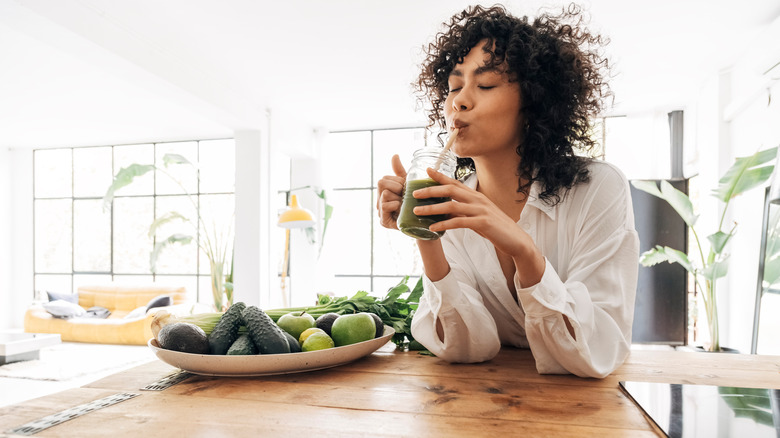 Woman drinking green juice