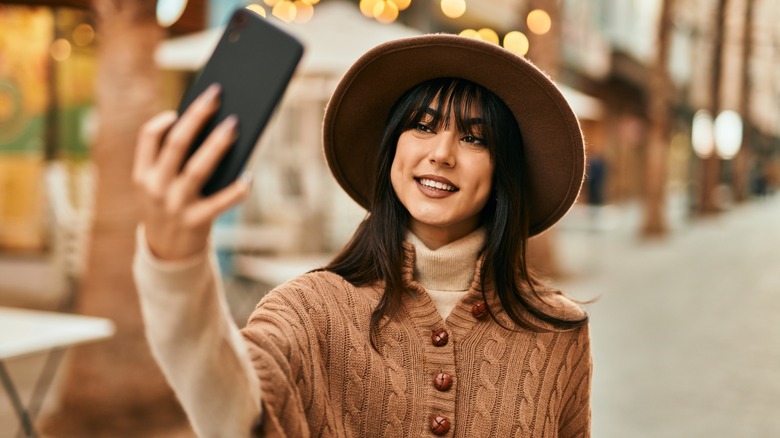 Woman with bangs taking video