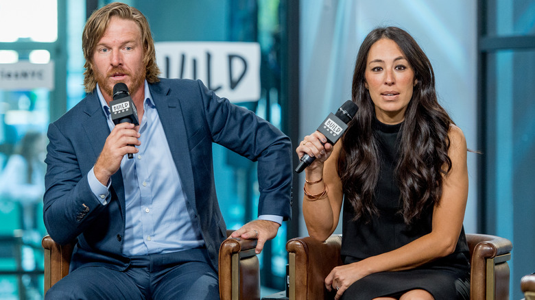 Chip and Joanna Gaines talking into microphones