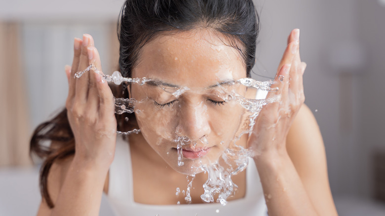 woman splashing water on face