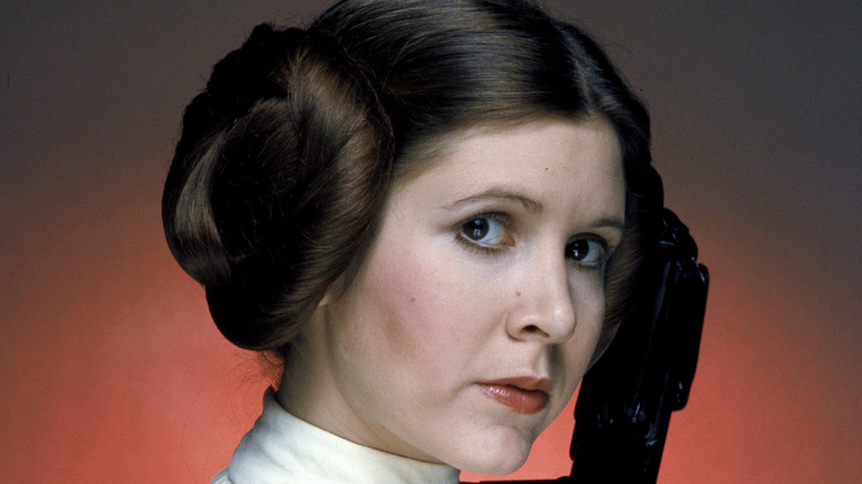 Princess Leia holds a weapon