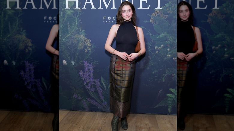 Carys Douglas wearing a high-neck black bodysuit with a patterned skirt