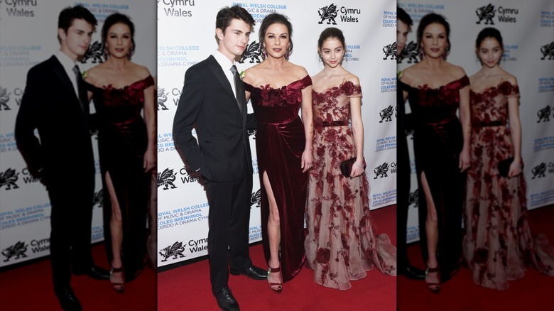 Carys Douglas wearing a red sheer dress with Catherine Zeta Jones and Dylan Douglas