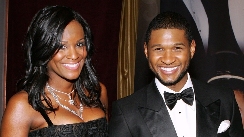 Usher in a tux and Tameka Foster wearing a black dress and diamond jewelry at an event.