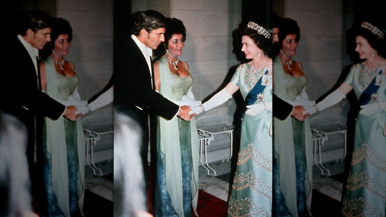 Elizabeth Taylor wearing a green dress with a scarf and statement jewelry meeting Queen Elizabeth wearing a dress with similar colors.