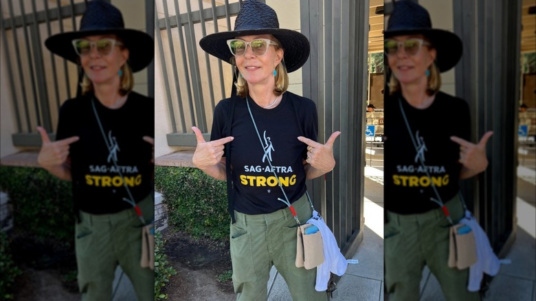 Allison Janney posing in a candid shot pointing at her SAG-AFTRA shirt while wearing sunglasses and a black hat.