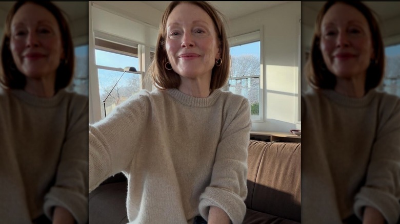 Julianne Moore posing in a selfie wearing a beige sweater and no makeup.