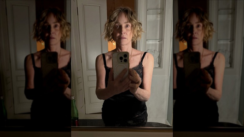 Sharon Stone posing for a mirror selfie with messy hair and no makeup.