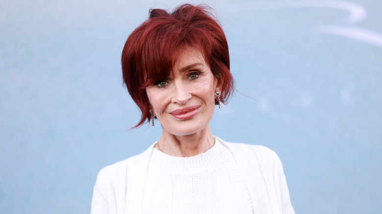 Sharon Osbourne smiling in a white outfit