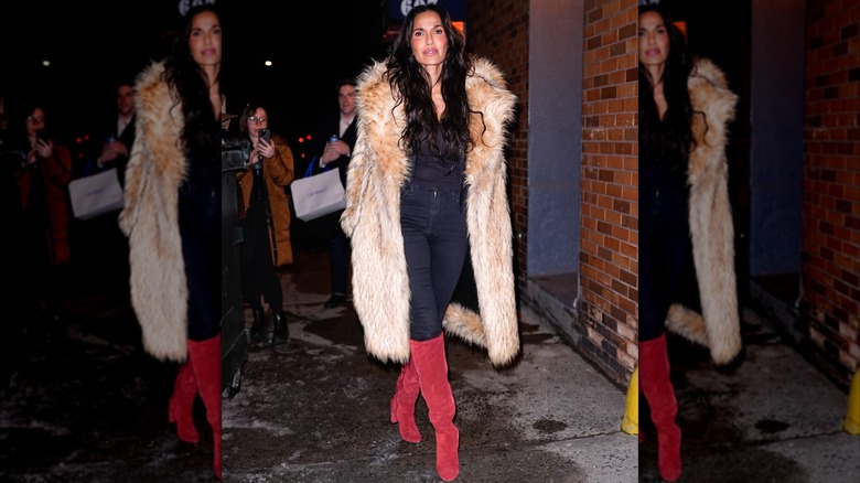 Padma Lakshmi wearing skinny jeans, red boots, and a fur coat in New York City in February 2026