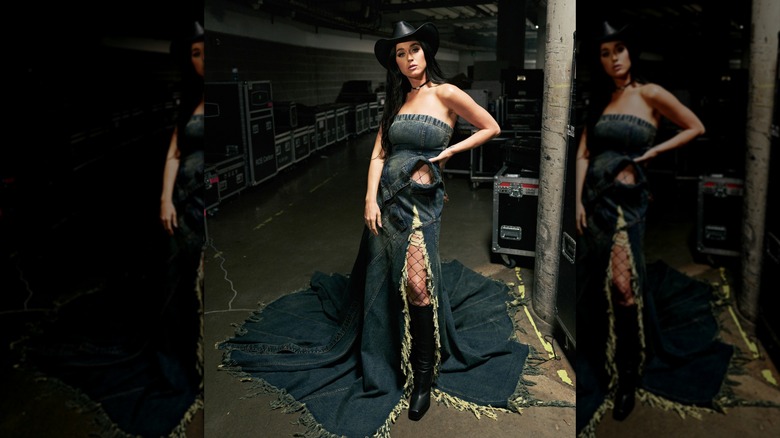 Katy Perry wearing a denim dress and a leather cowboy hat with cowboy boots