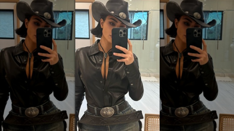 Kim Kardashian taking a selfie while wearing a Western outfit