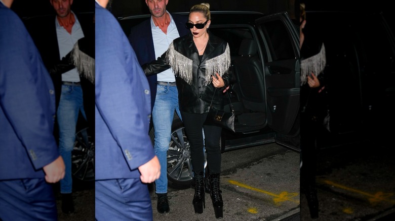 Lady Gaga walking in a leather jacket with cowboy fringe