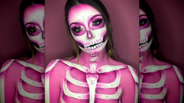 Girl with a full body of pink skeleton makeup.