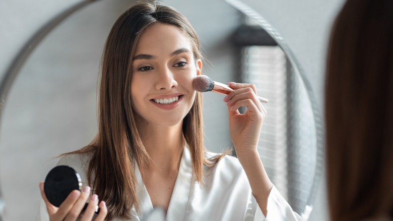 Woman applying blush