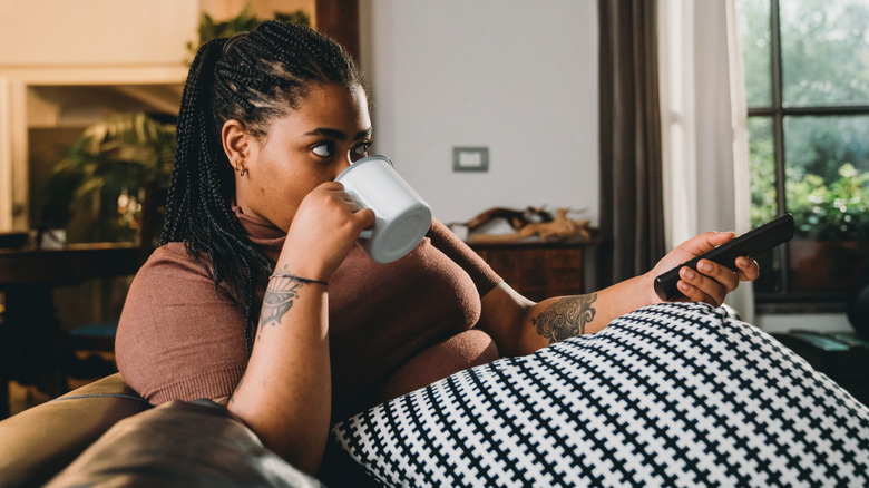 Woman watching show and drinking tea